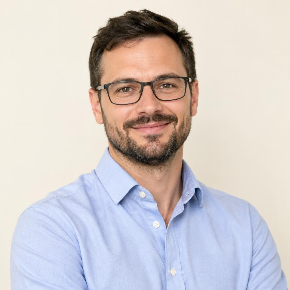 Smiling bearded man with glasses in business casual outfit